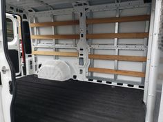 the back end of a white van with wooden shelves