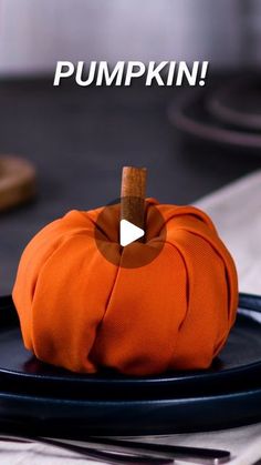 an orange pumpkin sitting on top of a black plate