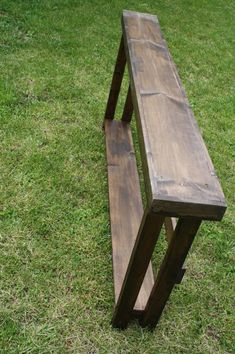 a wooden bench sitting on top of a lush green field