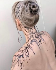 the back of a woman's head with tattoos on her upper and lower neck