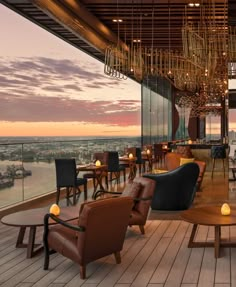 an outdoor restaurant overlooking the city at sunset