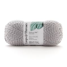 yarn ball in grey and white with green leaves on the top, against a white background