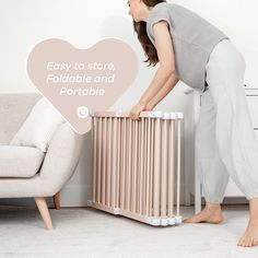 a woman is bending over to pick up a baby crib from the floor with her legs