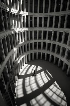 a person standing in the middle of a large building with lots of windows on it