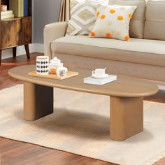 a coffee table sitting on top of a rug in front of a couch next to a window