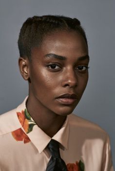 a woman wearing a floral shirt and tie