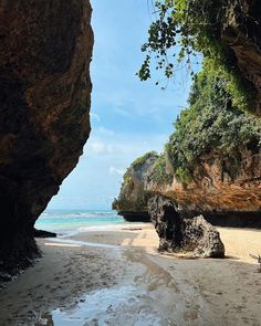 the beach is surrounded by large rocks and water