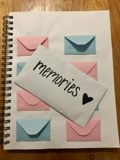 a notepad with the word memories written on it next to an envelope and heart