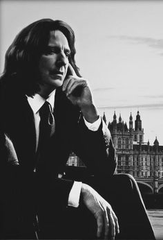 black and white photograph of a man sitting in front of big ben