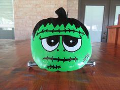 an inflatable halloween pumpkin with eyes and mouth on a wooden table next to a brick wall