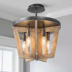 a light fixture hanging from the ceiling in a living room with two lights on it