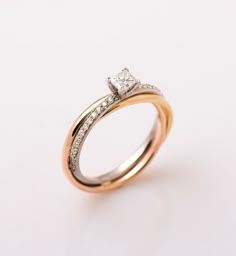 two tone gold wedding ring with diamond set in the center and side stones on each band