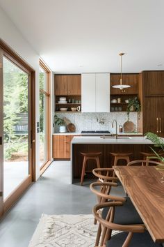 a kitchen with wooden cabinets and an island in the center is surrounded by wood chairs