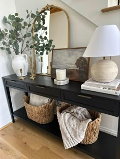 a black table with two baskets on it and a lamp in the corner next to it