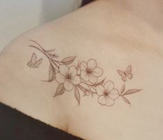 a woman's shoulder with flowers and butterflies on it