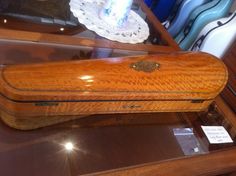 a wooden case sitting on top of a glass table next to a white doily