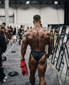 a man with no shirt on is walking down the runway at a bodybuilding competition