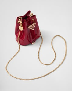 Drawstring closure Enameled metal triangle logo on closure Removable chain shoulder strap Leather interior Red Purse, Girly Bags, Red Purses