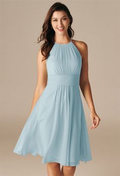 a woman in a blue dress smiling and posing for the camera with her hands on her hips