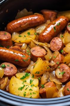 a crock pot filled with sausages, potatoes and onions