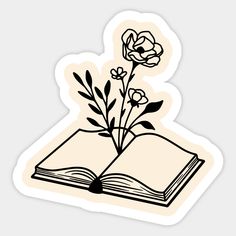 an open book with flowers sticking out of it