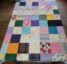 a multicolored patchwork quilt on a wooden floor