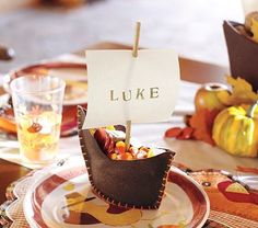 a table set for thanksgiving with plates and place settings