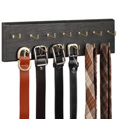 an assortment of belts hanging on a coat rack with metal hooks and leather straps in different colors