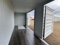 the inside of a storage container with wood flooring and white walls on one side