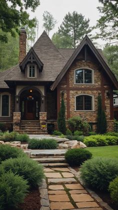 a house with stone steps leading up to the front door and entry way, surrounded by greenery