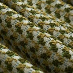 a close up view of a green and white fabric with small flowers on the side