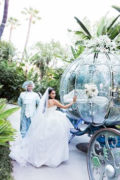 a bride and groom standing next to a horse drawn carriage in the middle of a garden