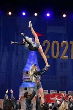 two women are doing acrobatic tricks on stage