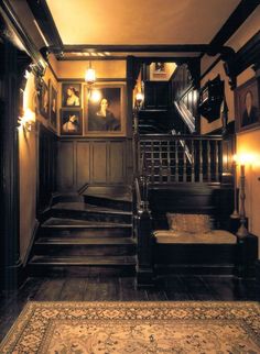 an old fashioned staircase with pictures on the wall