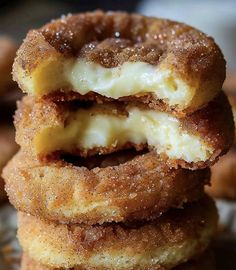 three doughnuts stacked on top of each other with one bite taken out of it