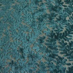 an upholstered blue and green fabric with small leaves on the side, as well as