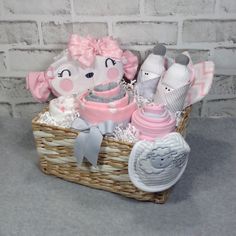 a basket filled with lots of baby items next to a brick wall in the background