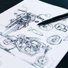 a pen is sitting on top of a piece of paper that has drawings of motorcycles