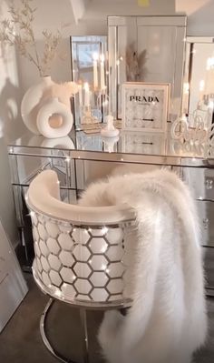 a white chair sitting on top of a metal table next to a mirror and candles