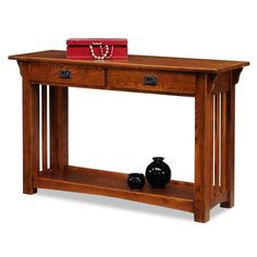 a wooden table with two drawers and a red purse on it's top shelf