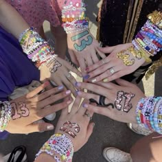 a group of people with their hands covered in bracelets