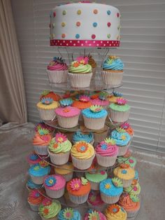 cupcakes are stacked on top of each other in front of a cake stand