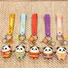 several key chains with panda bears on them sitting next to each other in front of a beige background