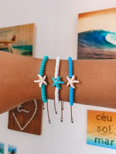 three bracelets with starfish charms are on someone's arm in front of some pictures