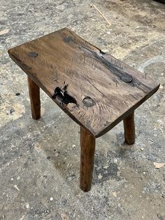 a small wooden table with scissors on it