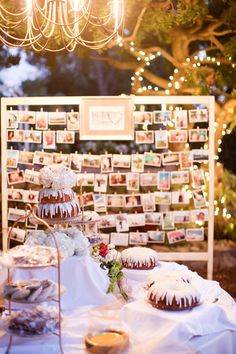 a table topped with cakes and desserts under a chandelier filled with lights