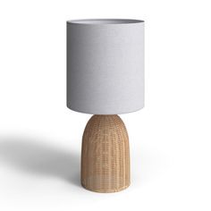 a wicker table lamp with a white shade on the top, and a light grey linen shade on the bottom