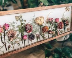 a wooden frame with dried flowers on it