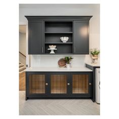 a kitchen with gray cabinets and white counter tops, along with a washer and dryer