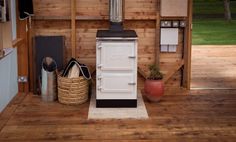 an old fashioned stove is in the corner of a room with wooden walls and flooring